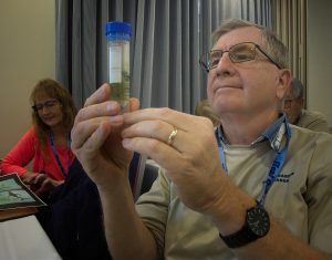 Student holding water sample vial